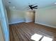 Well-lit bedroom boasts wood-look floors, a ceiling fan, and large windows at 603 Turnberry Ct, Albemarle, NC 28001