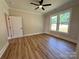 Bedroom with wood-look floors, ceiling fan, and windows providing natural light at 603 Turnberry Ct, Albemarle, NC 28001
