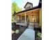 Inviting covered porch with classic lighting and brick accents leading to a beautiful glass front door at 603 Turnberry Ct, Albemarle, NC 28001