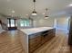 Bright open kitchen boasts a large marble island, pendant lighting, and views of the living area at 603 Turnberry Ct, Albemarle, NC 28001