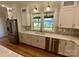 The gourmet kitchen features stainless appliances, a stylish backsplash, and bright white custom cabinets at 603 Turnberry Ct, Albemarle, NC 28001