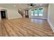 Spacious living room with hardwood floors, large windows, and a staircase leading to the upper level at 603 Turnberry Ct, Albemarle, NC 28001