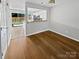 Open dining room with hardwood floors and view of kitchen, with access to outside patio at 6457 Saint Bernard Way, Charlotte, NC 28269