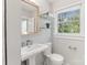 This bathroom features a pedestal sink, a window, and classic fixtures at 6609 Pleasant Dr, Charlotte, NC 28211