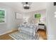 This bedroom features a bed with an upholstered headboard and a ceiling fan at 6609 Pleasant Dr, Charlotte, NC 28211