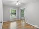Cozy bedroom features natural light from a window, a ceiling fan, and closet with mirrored doors at 6609 Pleasant Dr, Charlotte, NC 28211