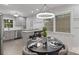 Bright dining area featuring a modern chandelier, large window, and seamless flow into the adjacent kitchen at 6609 Pleasant Dr, Charlotte, NC 28211