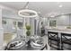 Open dining area with modern chandelier, seamlessly connected to a bright kitchen and a view of the living area at 6609 Pleasant Dr, Charlotte, NC 28211