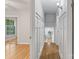 Bright hallway with beautiful hardwood floors and white trim, offering a glimpse into adjacent rooms at 6609 Pleasant Dr, Charlotte, NC 28211
