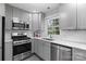 Contemporary kitchen featuring stainless steel appliances, gray cabinetry, and a bright window over the sink at 6609 Pleasant Dr, Charlotte, NC 28211