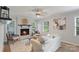 Inviting living room featuring a cozy fireplace, ceiling fan, and abundant natural light from two windows at 6609 Pleasant Dr, Charlotte, NC 28211