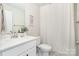 White bathroom with a single sink vanity, mirror, and shower with curtain at 6814 Forney Hill Rd # 2, Denver, NC 28037