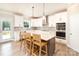 Modern kitchen boasts white cabinetry, stainless appliances, an island with seating, and stylish pendant lights at 6814 Forney Hill Rd # 2, Denver, NC 28037
