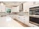 This modern kitchen features white cabinets, quartz countertops, a stylish backsplash, and stainless steel appliances at 6814 Forney Hill Rd # 2, Denver, NC 28037