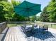Outdoor back deck featuring an umbrella, outdoor furniture, and a geometric rug, perfect for relaxing at 7728 Babe Stillwell Farm Rd, Huntersville, NC 28078