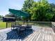 A cozy back deck with an umbrella offering shade and an outdoor dining set at 7728 Babe Stillwell Farm Rd, Huntersville, NC 28078