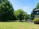 View of the lush backyard with a wooden deck and an umbrella for shade at 7728 Babe Stillwell Farm Rd, Huntersville, NC 28078