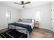 Bedroom features a ceiling fan, light hardwood floors, neutral walls, and a wrought iron bed frame at 7728 Babe Stillwell Farm Rd, Huntersville, NC 28078