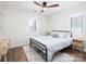 Sunlit bedroom showcasing a black metal bed frame, wood floors, and a ceiling fan at 7728 Babe Stillwell Farm Rd, Huntersville, NC 28078