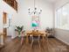 Inviting dining room featuring wood floors, modern chandelier, and a view to the open floor plan at 7728 Babe Stillwell Farm Rd, Huntersville, NC 28078