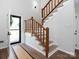 Bright entryway features natural wood stairs, modern lighting, and a glimpse of the outdoors at 7728 Babe Stillwell Farm Rd, Huntersville, NC 28078