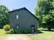 Inviting home exterior with cedar shake siding, updated door, and manicured landscaping at 7728 Babe Stillwell Farm Rd, Huntersville, NC 28078