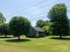 Charming home featuring green siding, stone accents, and a well-maintained lawn at 7728 Babe Stillwell Farm Rd, Huntersville, NC 28078