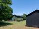 Exterior view of a home with green siding, black trim, and a back deck, surrounded by trees and a black shed at 7728 Babe Stillwell Farm Rd, Huntersville, NC 28078