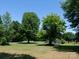 A wide shot of the home on a large lot with mature trees at 7728 Babe Stillwell Farm Rd, Huntersville, NC 28078