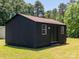 A dark-colored shed with a brown roof with a door and window accents at 7728 Babe Stillwell Farm Rd, Huntersville, NC 28078