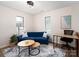 Bright sitting room features a blue sofa, hardwood floors, and a modern desk at 7728 Babe Stillwell Farm Rd, Huntersville, NC 28078