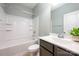 Bathroom with a white shower-tub combo and a vanity featuring a countertop and dark cabinets at 8268 Breton Way, Harrisburg, NC 28075