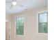 Bright bedroom with two windows and blinds allowing natural light to illuminate the neutral-colored walls and ceiling fan at 8268 Breton Way, Harrisburg, NC 28075