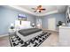 Primary bedroom features a tray ceiling, ceiling fan, neutral walls, and an ensuite bathroom at 8268 Breton Way, Harrisburg, NC 28075