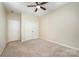Bedroom featuring neutral walls, ceiling fan, and carpet flooring, with a closet and two doors at 8268 Breton Way, Harrisburg, NC 28075