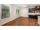 Bright dining area features hardwood floors, glass doors to the outside, and access to the kitchen with dark wood cabinets at 8268 Breton Way, Harrisburg, NC 28075