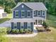 Charming two-story home with blue siding, shutters, well-maintained landscaping, and a walkway to the front door at 8268 Breton Way, Harrisburg, NC 28075