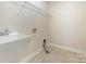 Spacious laundry room with a utility sink, tiled floor, and washer-dryer hookups at 8268 Breton Way, Harrisburg, NC 28075