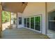 Covered back porch features natural wood flooring, a ceiling fan, and sliding glass doors to the interior at 104. Wilharr Ct # 40, Mooresville, NC 28115