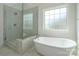 Bright bathroom featuring freestanding tub, tiled shower, and a large window at 104. Wilharr Ct # 40, Mooresville, NC 28115