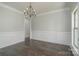 Elegant dining room with dark wood floors, classic wainscoting, and a stylish chandelier at 104. Wilharr Ct # 40, Mooresville, NC 28115