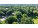 Aerial view of a house nestled in a lush, green neighborhood with mature trees at 116 Barnes Ln, Stony Point, NC 28678