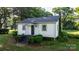 Quaint home with a covered front porch, surrounded by lush greenery and mature trees at 116 Barnes Ln, Stony Point, NC 28678