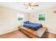 Bedroom features a wooden platform bed, two windows, and neutral-colored walls and carpet at 117 Ethel Ln, Statesville, NC 28625