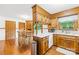 Well-lit eat-in kitchen features wood cabinets, white counters, hardwood floors, and stainless trash receptacle at 117 Ethel Ln, Statesville, NC 28625