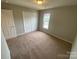 Bedroom with neutral carpet, double closet, and a window at 118 Steam Engine Dr # 201, Mooresville, NC 28115