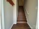 A well-lit staircase with hardwood steps and a coat rack for a welcoming entrance at 118 Steam Engine Dr # 201, Mooresville, NC 28115