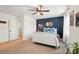 Stylized bedroom featuring a white bed frame, dark blue accent wall, and ceiling fan with decorative lighting at 12021 Basking Dr, Charlotte, NC 28214