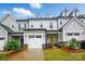 Charming townhome with a one-car garage, yellow front door, and nicely landscaped front yard at 12021 Basking Dr, Charlotte, NC 28214