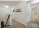 Hallway with neutral carpet, white walls, decorative shelves, and a view into a bathroom at 12021 Basking Dr, Charlotte, NC 28214